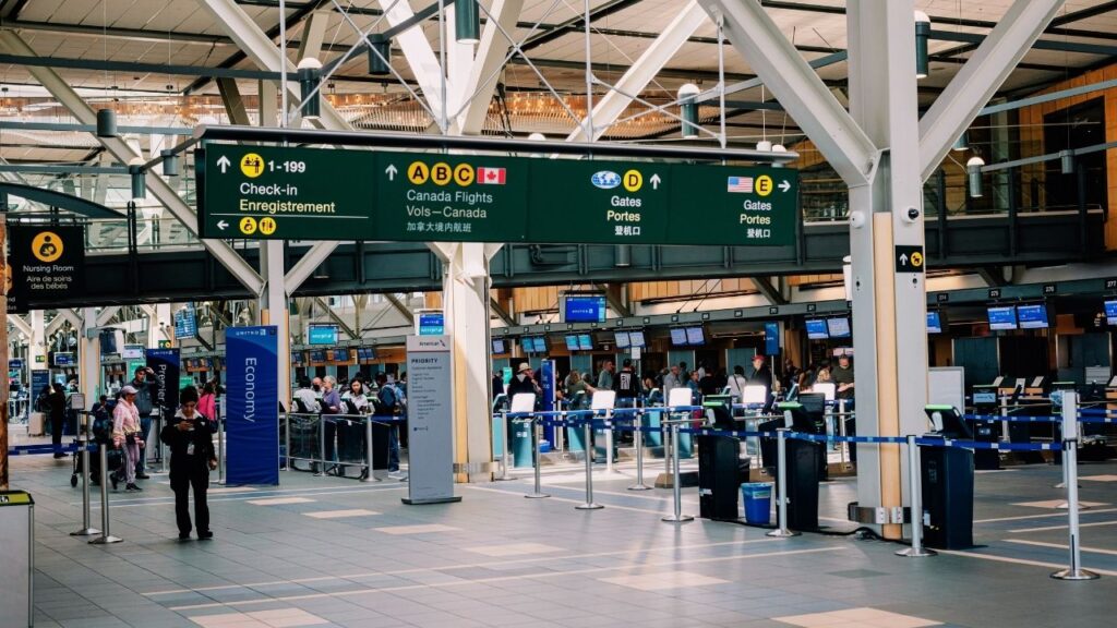 Busy airport check-in area with unclear signage and multiple lines, illustrating confusion in a premium travel user experience.